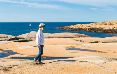 Woman walking at beach against sky