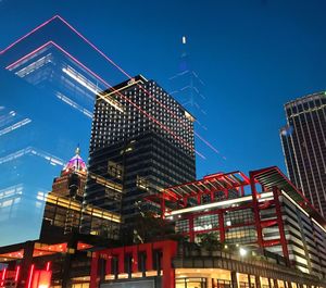 Low angle view of illuminated buildings against clear sky at night