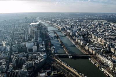 High angle view of illuminated city by river against sky