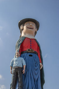 Low angle view of child standing against sky