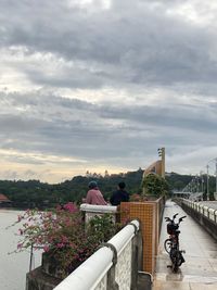 Bicycle on bridge in city against sky