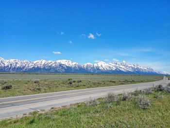 Scenic view of landscape against blue sky during winter