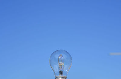 Low angle view of street light against blue sky