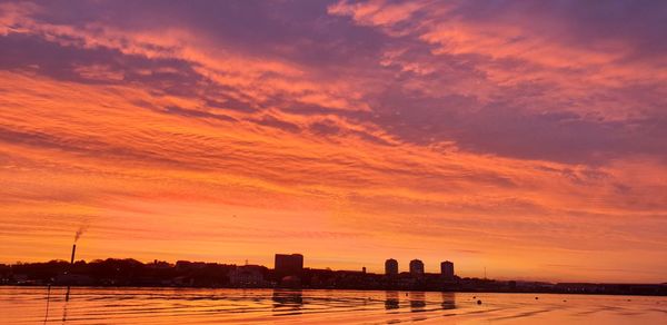 Silhouette buildings against sky during sunset