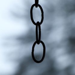 Close-up of chain hanging against sky