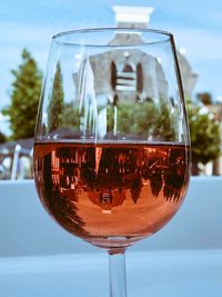 Close-up of wineglass on table against sky