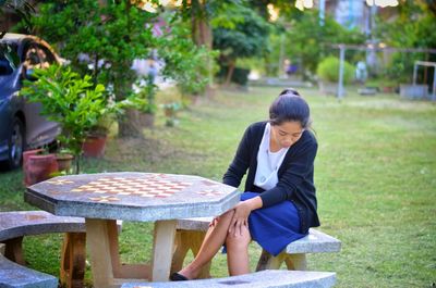 Woman sitting at table in lawn