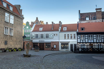 Street by buildings in city against sky