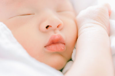 Close-up of baby lying on bed