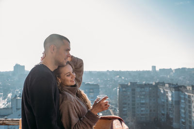 Young couple drinking coffee on the balcony of the apartment in the morning. young happy couple