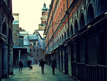 People walking in city against sky