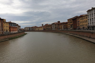 River amidst buildings in city against sky