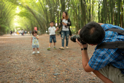 Rear view of two people with arms raised against trees