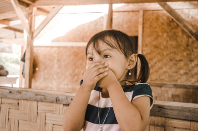 Shocked girl covering mouth at home