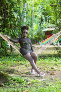 Portrait of young woman sitting on tree