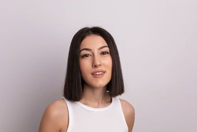 Portrait of young woman against white background