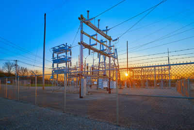 Electricity pylon against sky during sunset