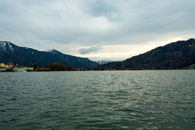 Scenic view of lake by mountains against sky