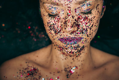 High angle view of shirtless woman with colorful make-up