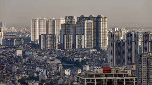 Aerial view of buildings in city against sky