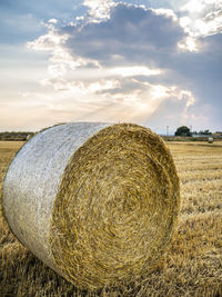 Hay bales on field against sky