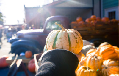 Close-up of person holding pumpkin outdoors