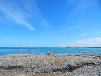 Boats in sea against blue sky