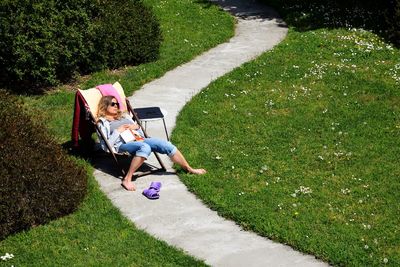 Full length of woman resting on chair in back yard
