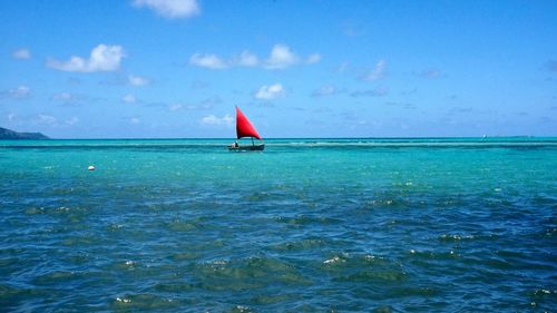 Sailboat in sea against blue sky