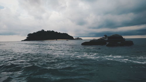 Rocks in sea against sky