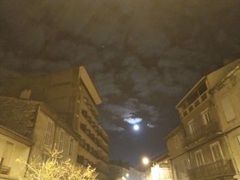 Low angle view of illuminated buildings against sky at night