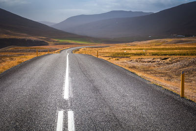 Empty road leading towards mountains