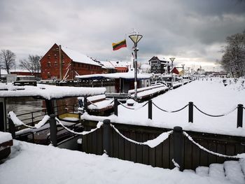 Snow covered ships against sky during winter