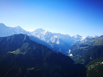 Scenic view of snowcapped mountains against clear blue sky