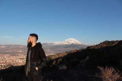 Man standing on mountain against clear sky