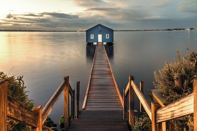 Wooden pier over lake against sky