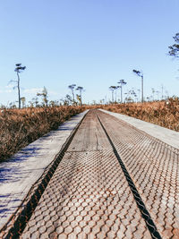 Surface level of railroad track against clear blue sky