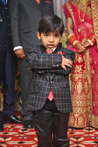 Portrait of cute girl wearing suit standing during wedding ceremony