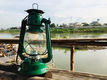 View of lantern by river against sky