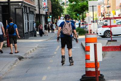 Rear view of man roller skating on street