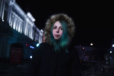 Young woman standing outdoors at night