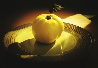 Close-up of yellow fruit in plate on table