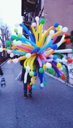 Close-up of multi colored umbrella walking on road