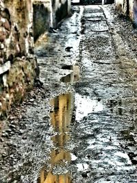 Reflection of old building in puddle on road