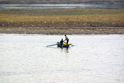 Men sitting in boat on river