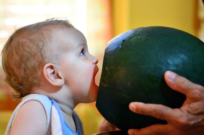 Side view of cute baby eating watermelon