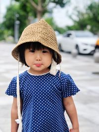 Portrait of cute girl wearing hat standing outdoors