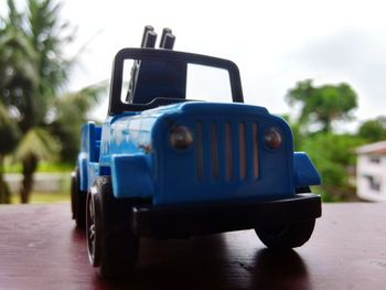 Close-up of vintage car on road against blue sky