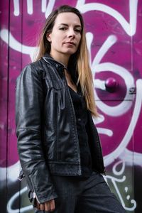 Portrait of mid adult woman standing against wall