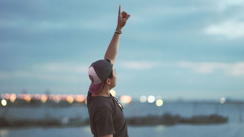 Side view of man standing in sea against sky